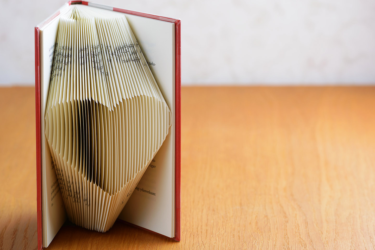 Book art with book open and a folded heart made of paper in 3D facing front