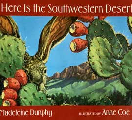 Illustrated green prickly pear cactus with red fruit, brown jackrabbit face with ears, mountain in background with blue sky. Brick colored border on top and bottom with white lettering "Here is the Southwestern Desert" on top, "by Madeleine Dunphy Illustrated by Anne Coe" on bottom