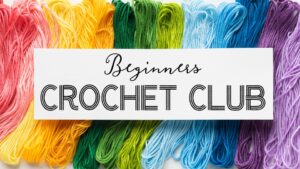 rainbow colored embroidery thread in background. White rectangle with black lettering "Beginners Crochet Club" in foreground