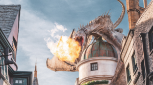 Banner image for event listing. Dragon on top of a castle breathing out fire.