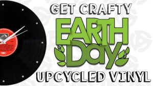 White background with light gray circles. Half a black record with red label on it towards left. In foreground: "Get Crafty" white block letters on top, "Upcycled Vinyl" in white block letters at bottom, "Earth Day" in green block letters in middle