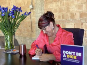 Photo of author signinga book titled Dont' Be a D!ick