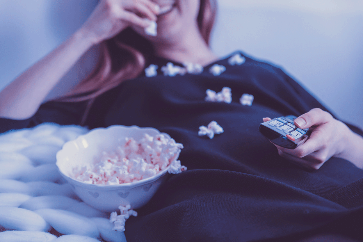 woman in black dress eating popcorn movie light